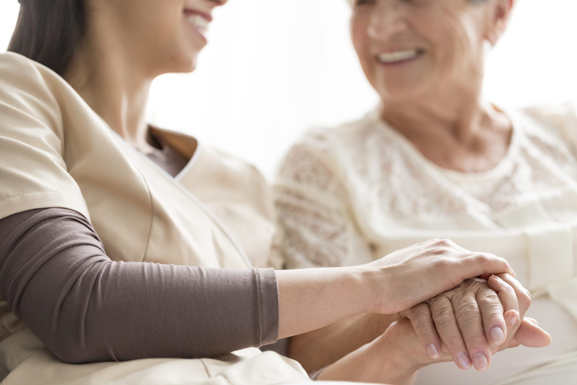 Close-up of person touching hand of senior woman. Caregiving in the nursing home